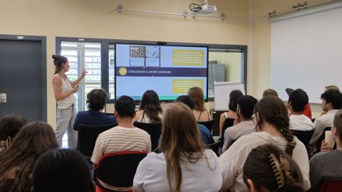 Personas sentadas en una sala escuchando una presentación.